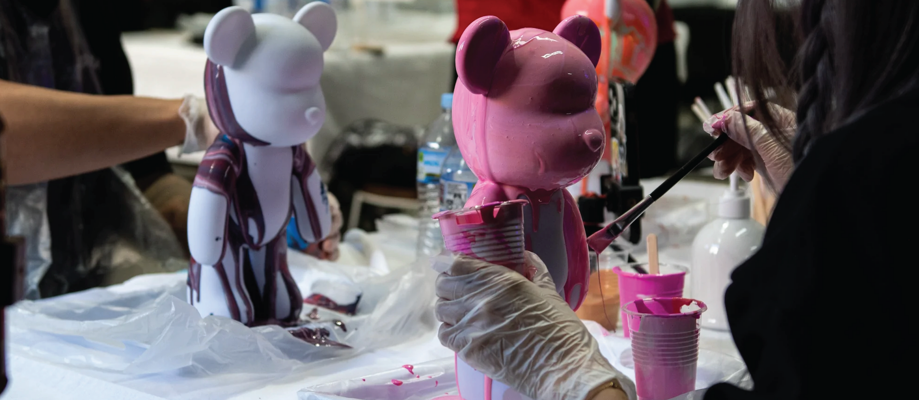 A white and pink bear being painted at the Fluid Project workshop